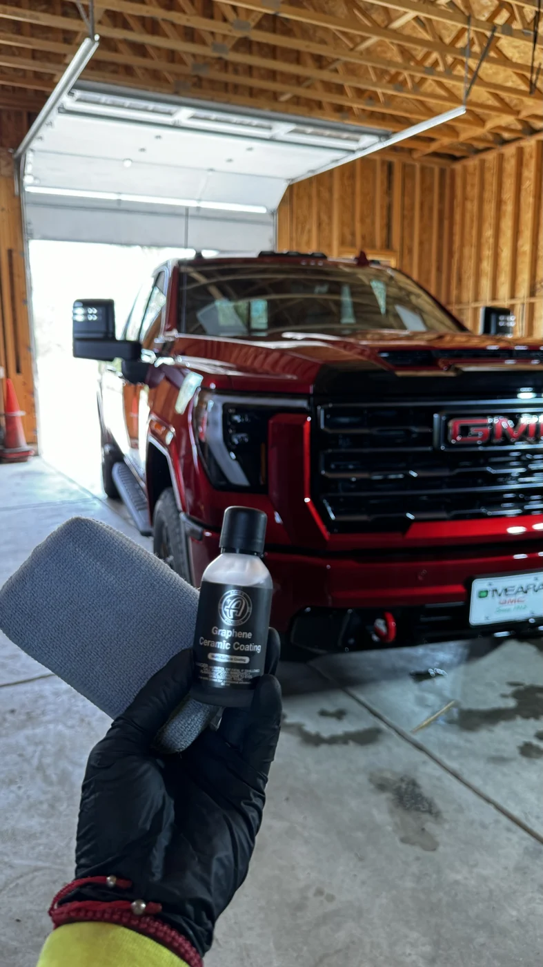 Coating bottle held in front of a red GMC truck at Power Pro Studios