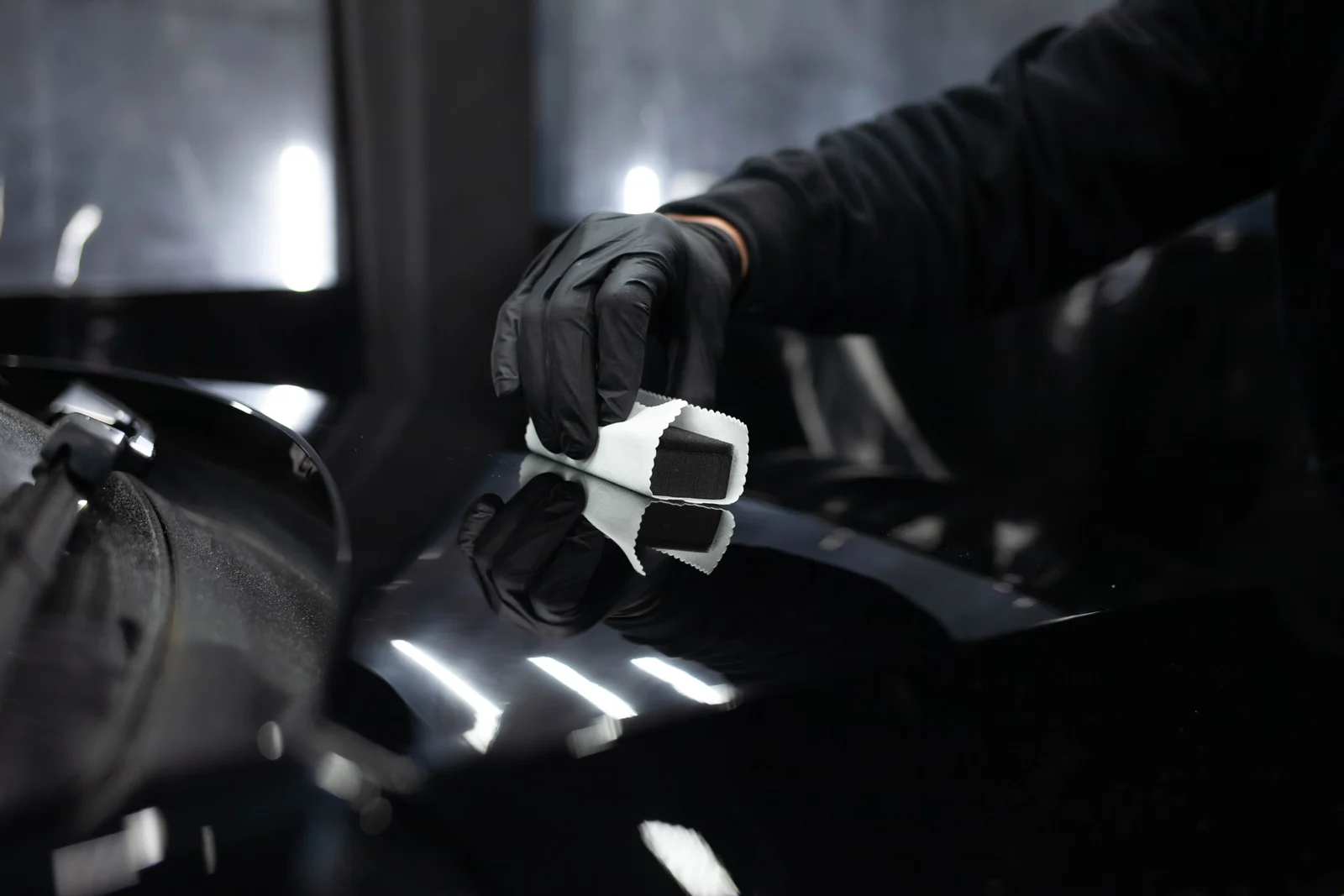 Close-up of a ceramic coating being carefully applied to paint